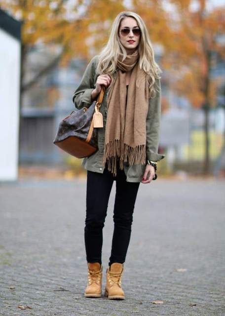 With green army shirt, oversized scarf and black pants