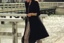 With knee-length black coat and pumps