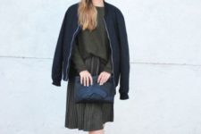 With olive green shirt and pleated skirt