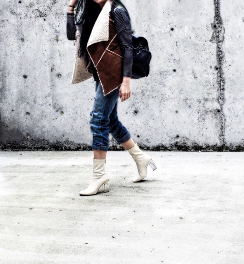 With shearling vest, crop jeans and bag