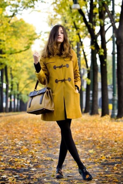 With two color bag, black skirt, black tights and flat shoes