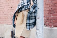 With white sneakers and oversized plaid scarf