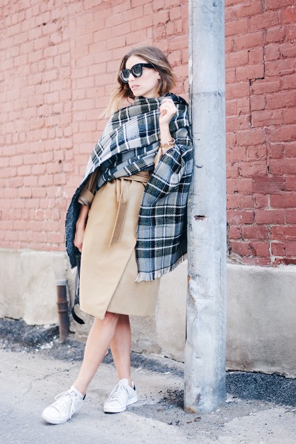 With white sneakers and oversized plaid scarf