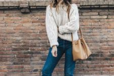 With white sweater, cuffed jeans and camel bag