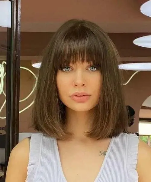 a brown long bob with a classic fringe and a lot of volume will give you a doll-like look