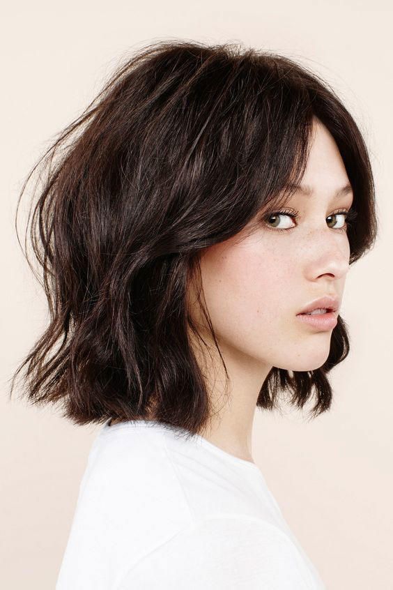 a dark brunette wavy long bob with a lot of volume is a stylish and chic idea for a modern and bold look