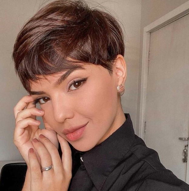 a layered pixie haircut in a rich brown shade, with soft layers that create movement plus a long fringe to accent the eyes