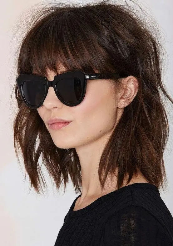 a shaggy brown shoulder-length bob with classic bangs and messy waves is a very rock-n-roll idea to rock