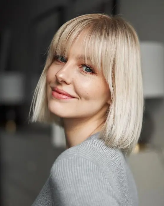 an icy blonde long bob with wispy bangs is a stylish and catchy idea to rock right now, it seems simple but it's classic