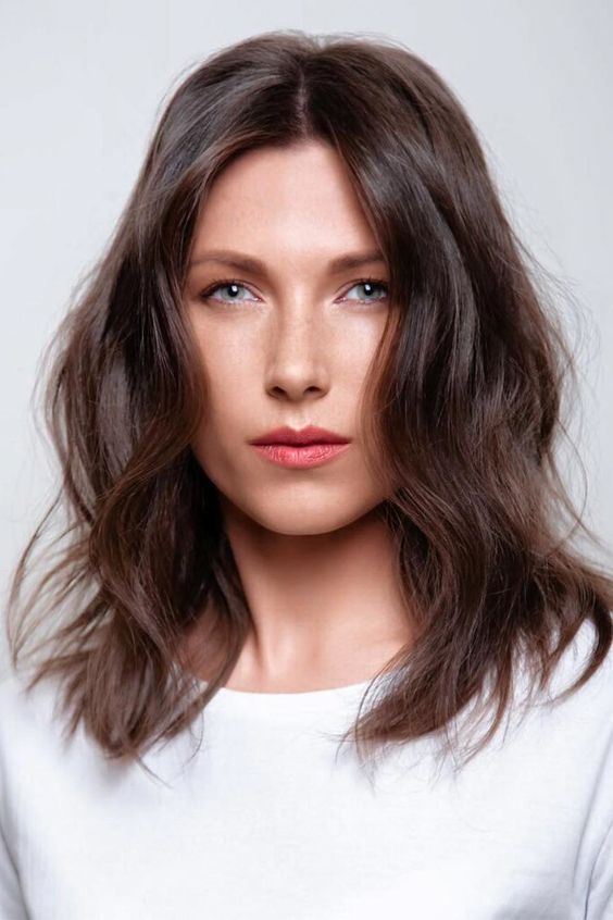 medium-length chestnut hair with waves and volume looks pretty, catchy and stylish