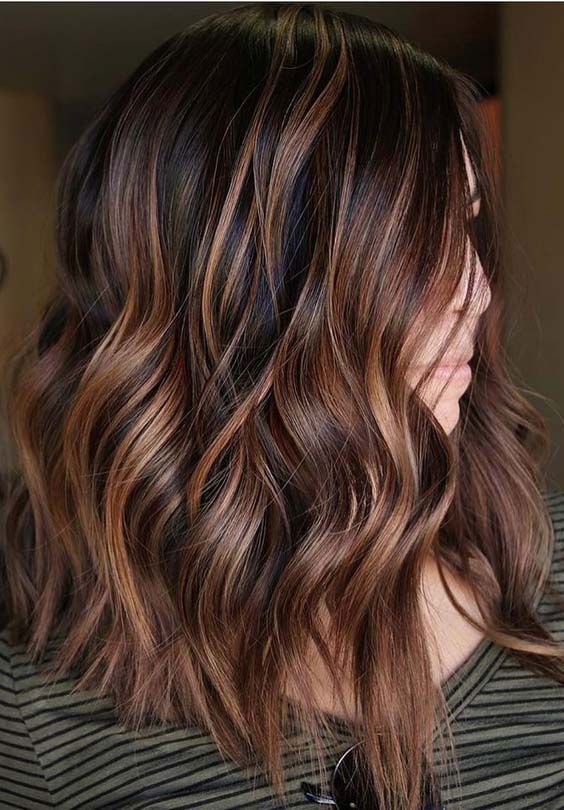 medium-length dark hair with chestnut and copper balayage, waves and volume, is a stylish and chic idea