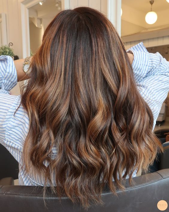 Medium length dark hair with chestnut balayage and waves and volume is a beautiful solution to rock