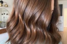 medium-length wavy chestnut to caramel hair with a lot of volume is a catchy and chic solution