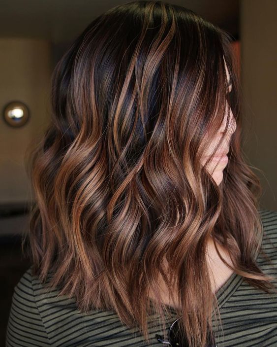 Shoulder length dark hair with chestnut and copper balayage, waves and volume, is a catchy and cool idea