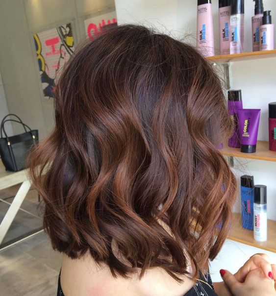 Shoulder length dark hair with chestnut balayage, waves and volume is a stunning and refined idea to rock