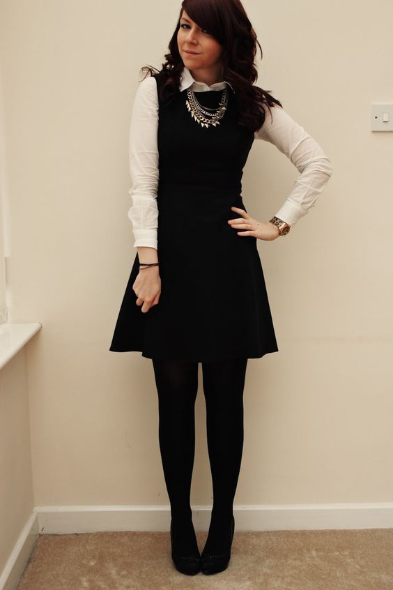 a button down under a sleeveless dress with tights