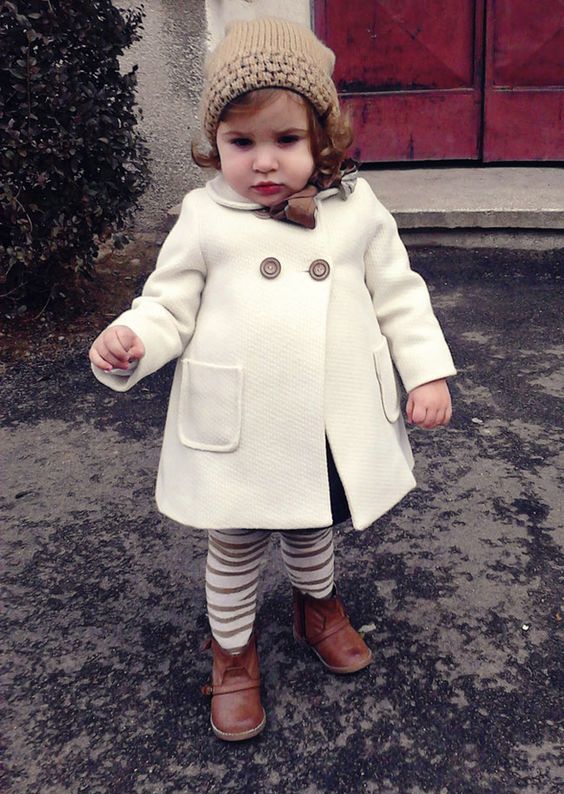 a white coat, striped leggings, a beanie and boots