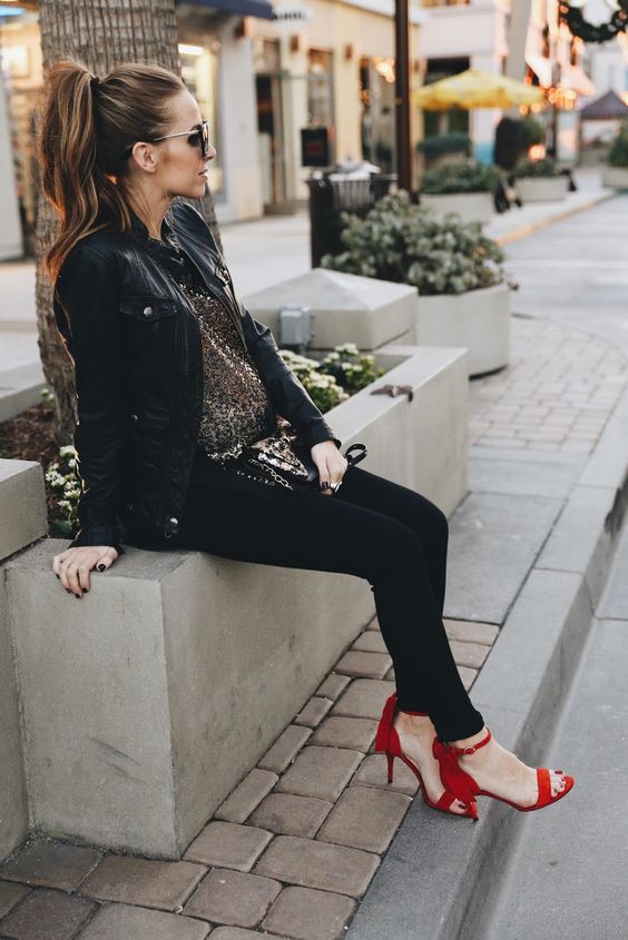 a leather jacket, black leggings, a sparkly tunic and red heels