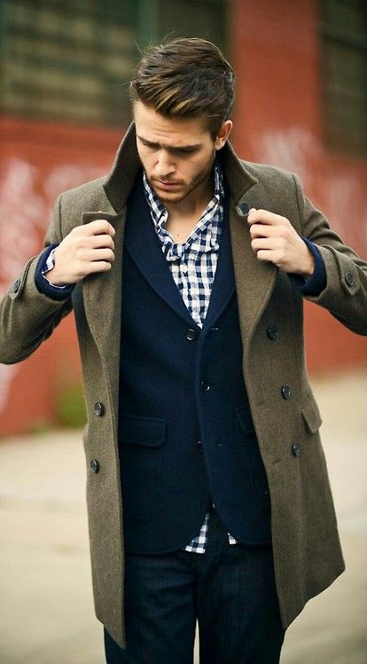 jeans, a navy tweed jacket, a plaid shirt and an olive green coat over