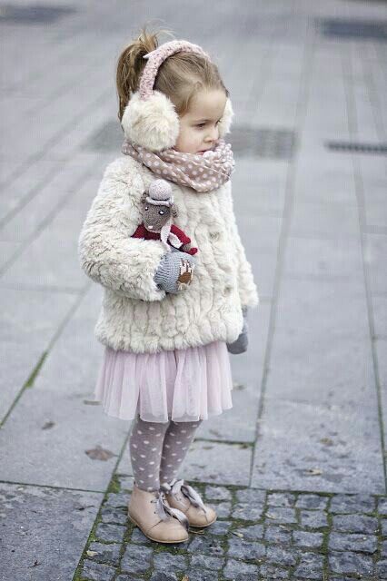 a faux fur coat and earmuffs, a tulle pink skirt, polka dot tights and boots