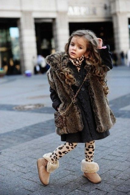 a fur coat, a knit black dress, leopard tights and faur ugg boots