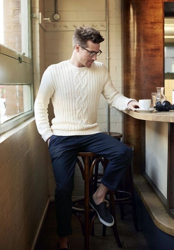 navy pants, a white cable knit sweater and slip-ons
