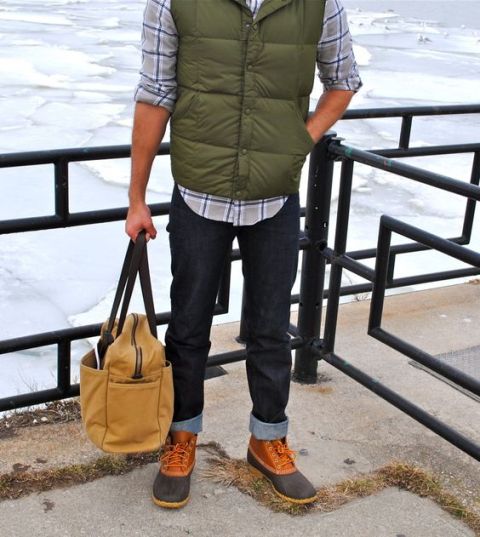 With plaid shirt, puffer vest, cuffed jeans and big bag