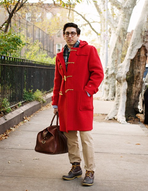 With plaid shirt, red duffle coat, camel pants and leather bag