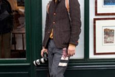With tweed blazer, gray pants and beanie