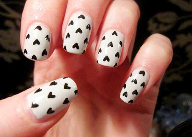 white nails with black hearts made with a sharpie
