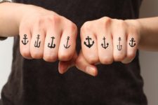 Black anchor tattoos on the fingers