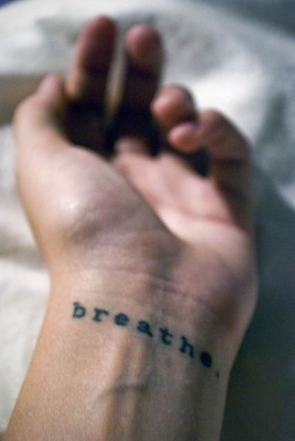Black word tattoo on the left wrist