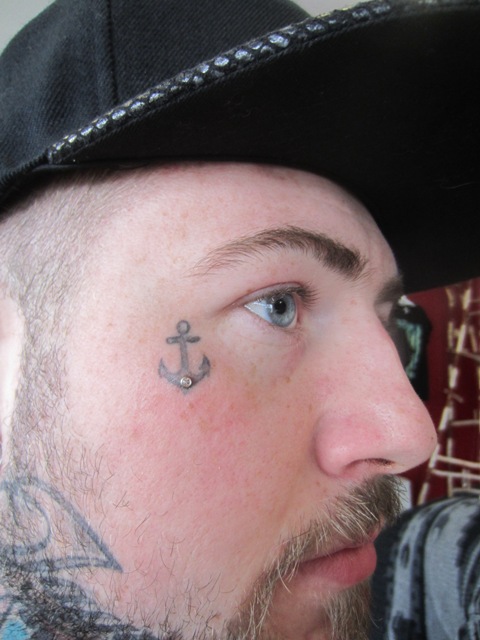 Tiny anchor tattoo on the face