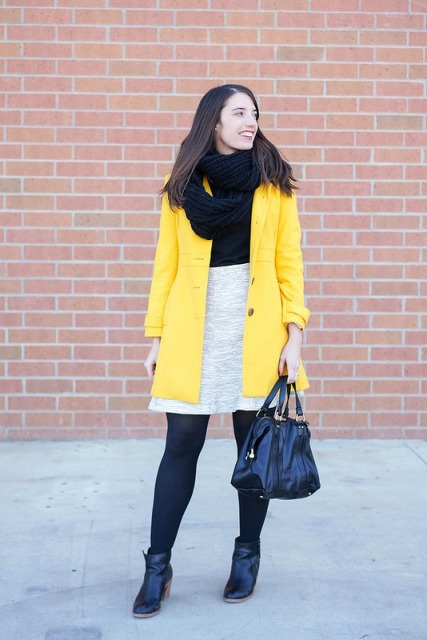 With black shirt, light gray skirt, black tights, ankle boots, leather bag and yellow mini coat