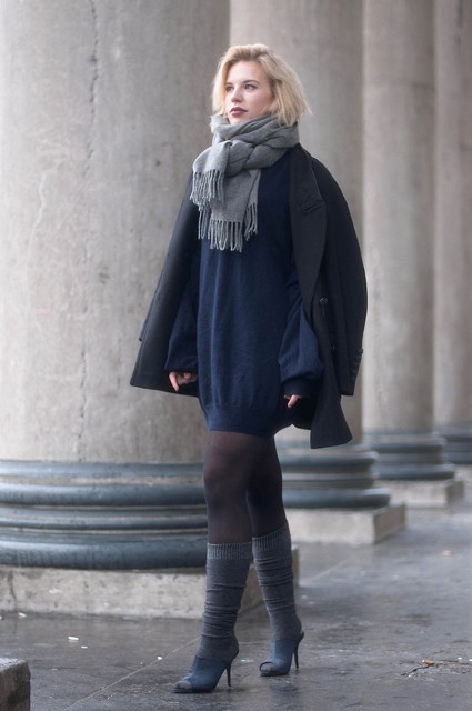 With navy blue mini dress, gray boots and black coat