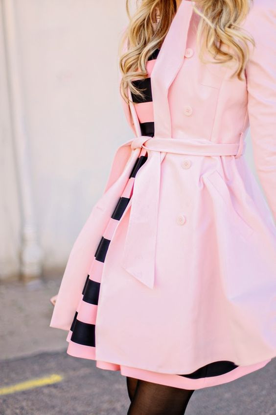 a pink and black striped dress and a pink coat over it