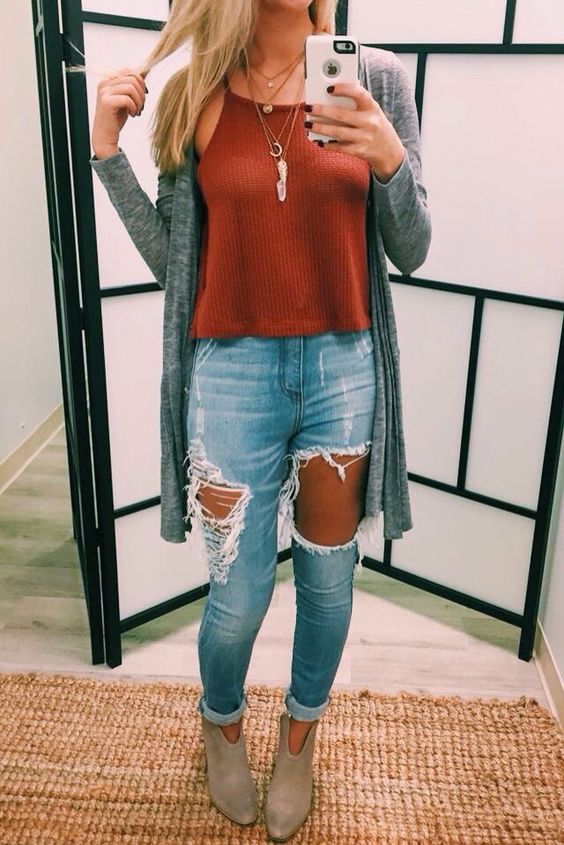 ripped jeans, a red top, a grey cardigan and ankle booties
