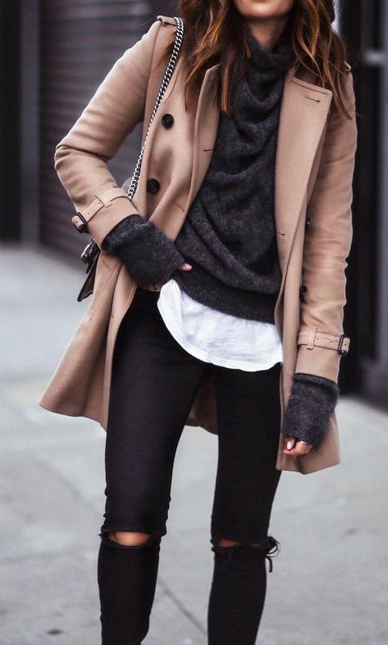 a short ocher coat, a black sweater and a white tee