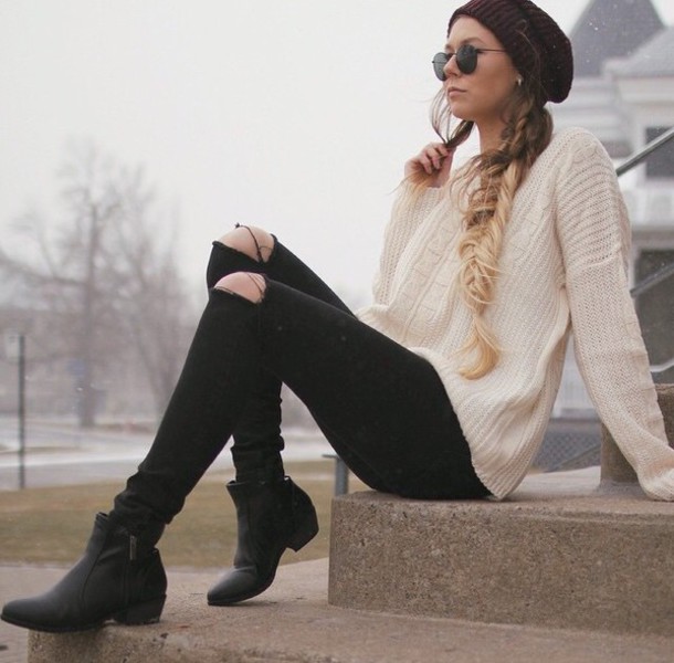 ivory oversized swetaer, a burgundy beanie, ripped jeans and boots