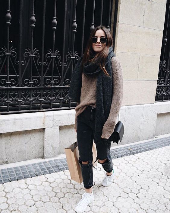 black ripped jeans, a brown oversized sweater and an oversized scarf, sneakers