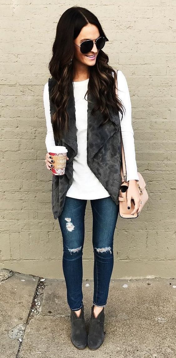 ripped fitted jeans, a white sweater, a faux fur vest and suede ankle booties