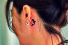 Black tattoo behind the ear