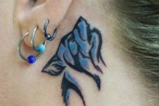 Blue wolf tattoo behind the ear