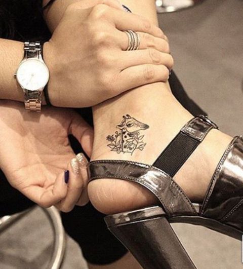 Giraffe head tattoo on the ankle