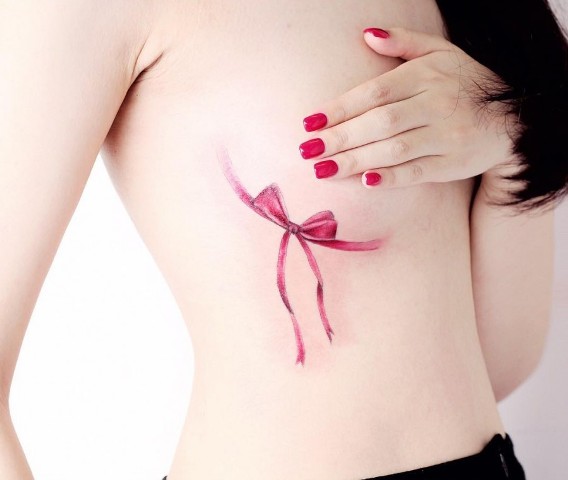 Pink bow tattoo on the chest