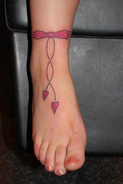Pink ribbon bow tattoo on the ankle