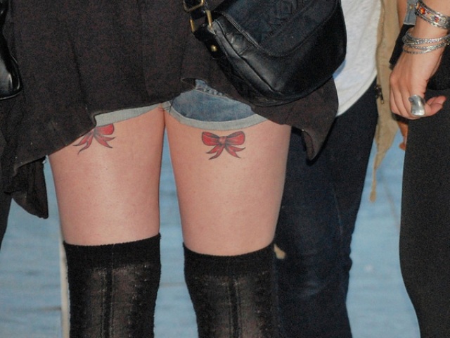 Red bow tattoos on the legs