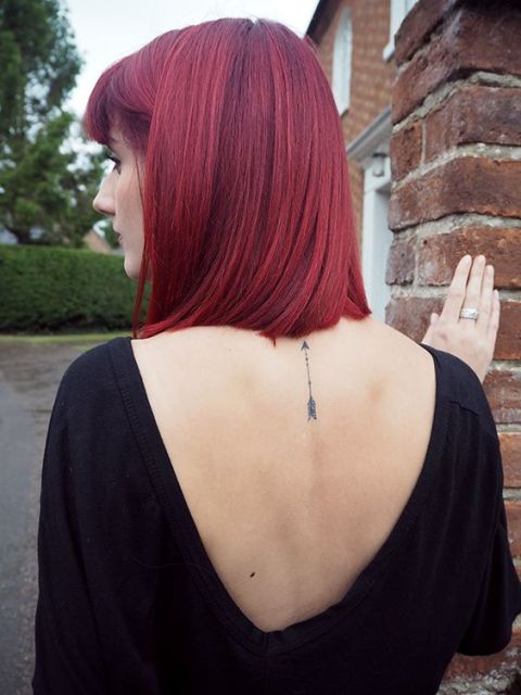 Small arrow tattoo on the back