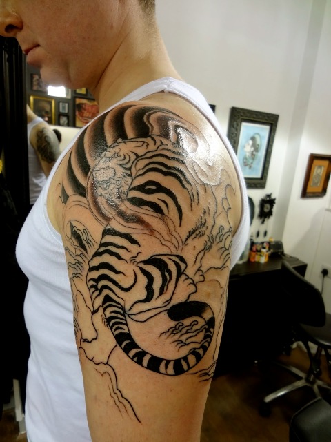Tiger half sleeve tattoo on the left arm