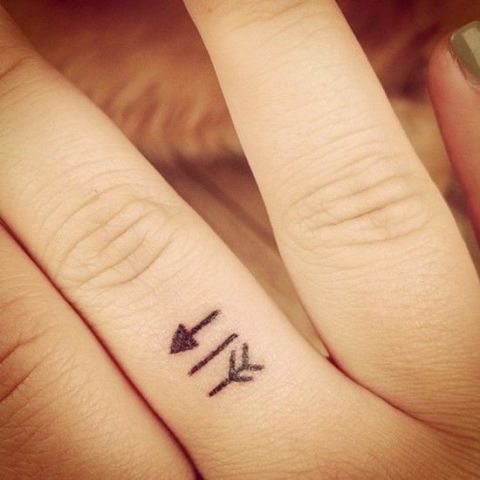 Tiny arrow tattoo on the finger